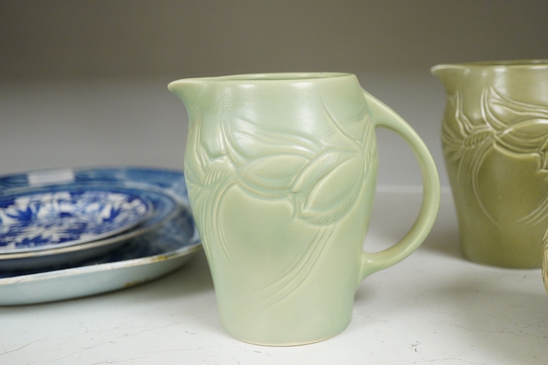 Three Susie Cooper green floral incised jugs, signed to the bases, tallest 16cm high